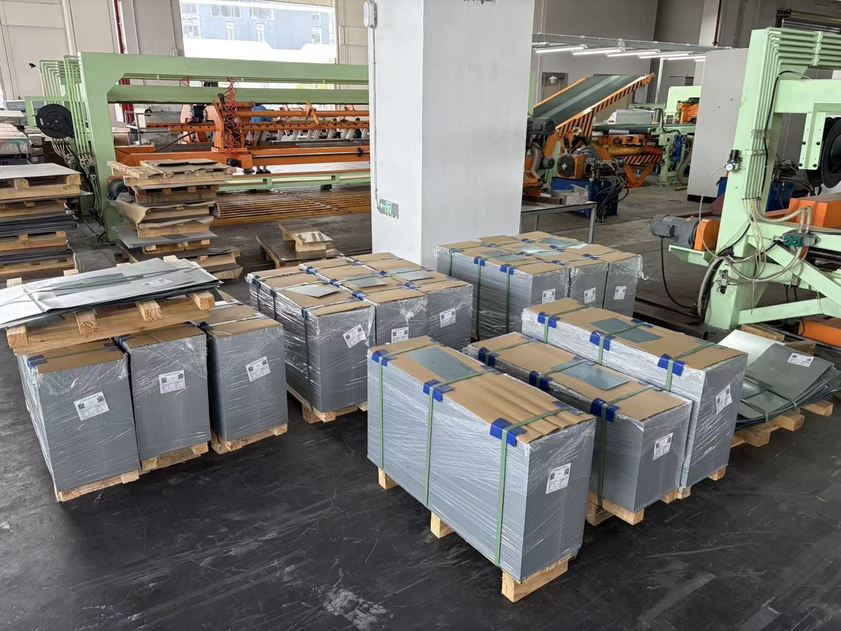 Packaged cut-sheet bundles beside RONGXING processing equipment