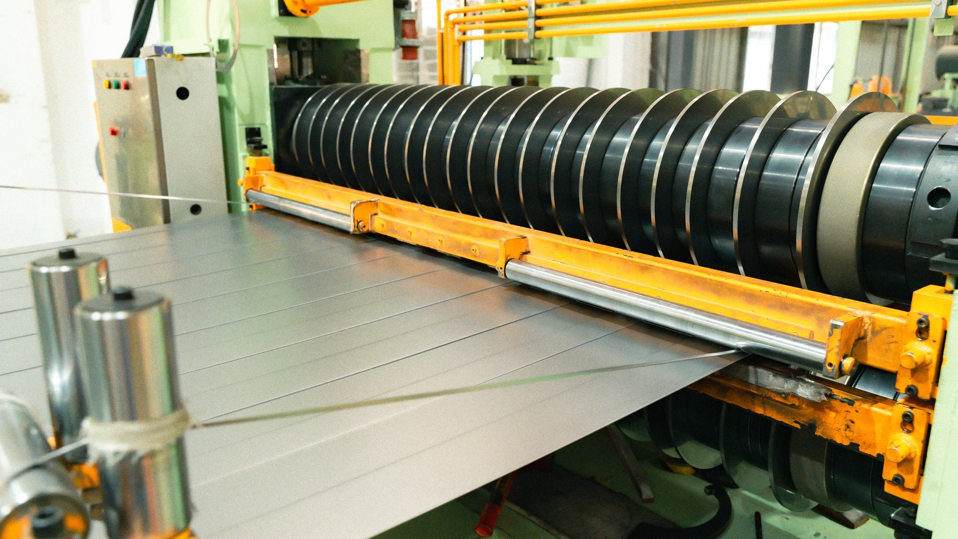 Circular knives separating a wide strip into controlled narrow strips